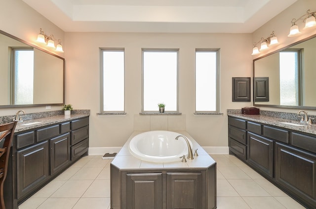 bathroom with tile patterned flooring, vanity, and a bath