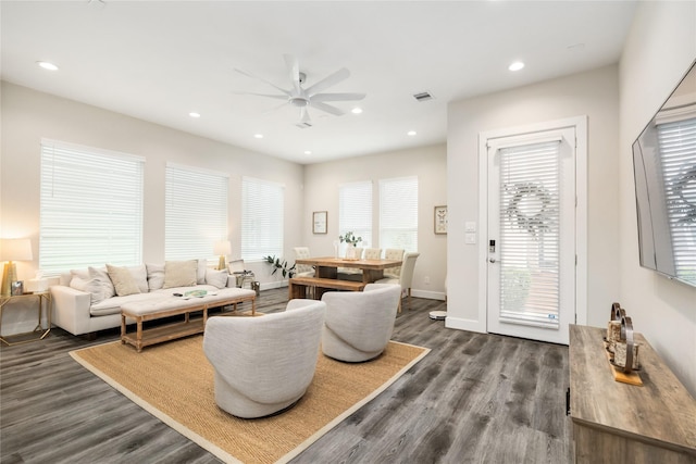 living room with dark hardwood / wood-style flooring and ceiling fan