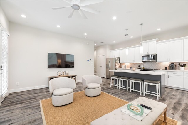 living room featuring ceiling fan and dark wood-type flooring