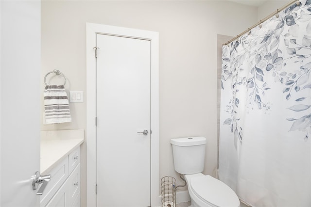 bathroom with curtained shower, vanity, and toilet