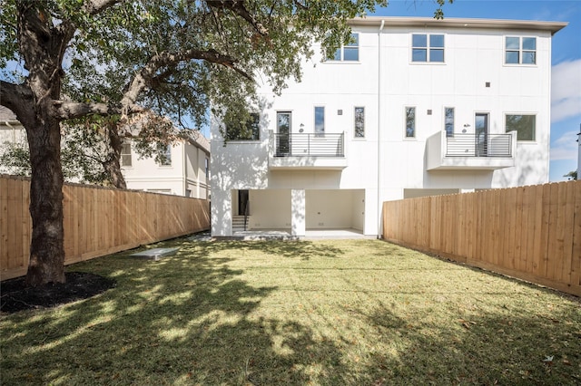 back of property with a lawn and a patio