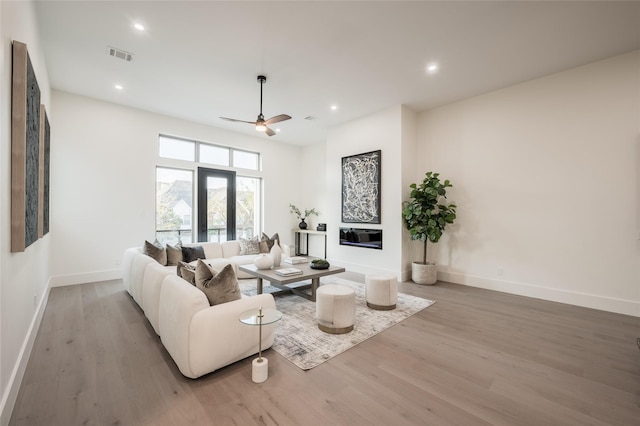 living room featuring ceiling fan, wood-type flooring, and french doors