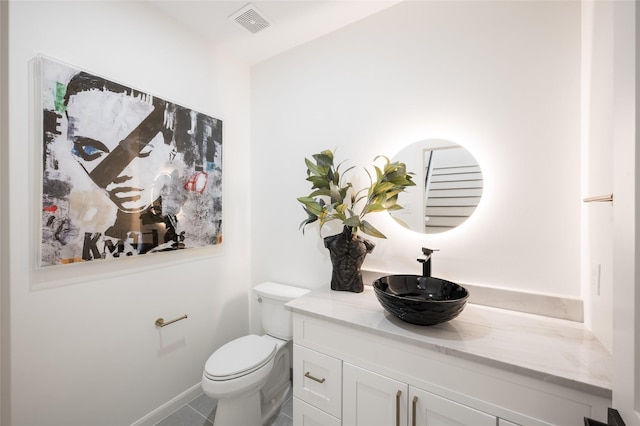 bathroom featuring tile patterned floors, vanity, and toilet