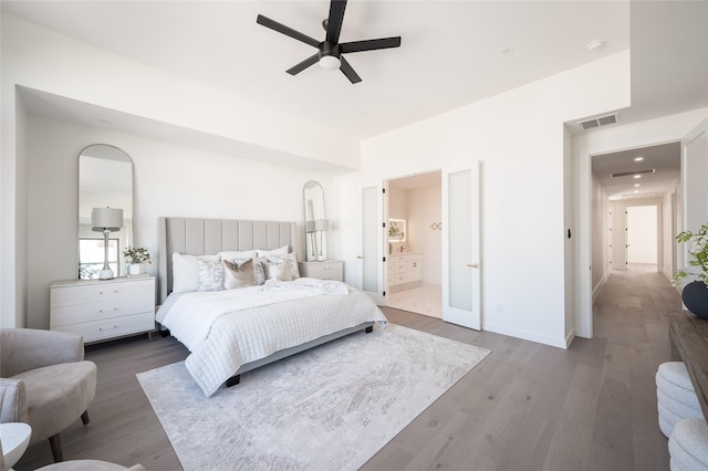 bedroom with hardwood / wood-style floors, ceiling fan, and ensuite bathroom