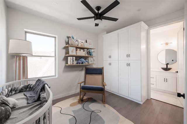 living area featuring dark hardwood / wood-style flooring, ceiling fan, and sink