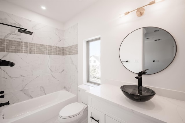 full bathroom with tiled shower / bath combo, toilet, and vanity