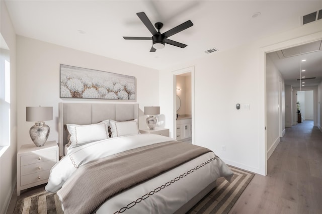 bedroom with connected bathroom, ceiling fan, and hardwood / wood-style floors