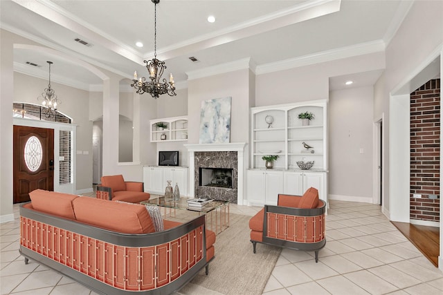 living room featuring crown molding, light tile patterned floors, and a notable chandelier