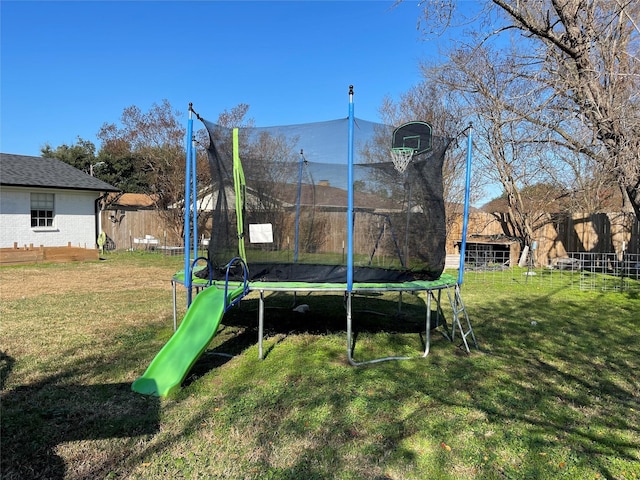 view of jungle gym with a lawn and a trampoline