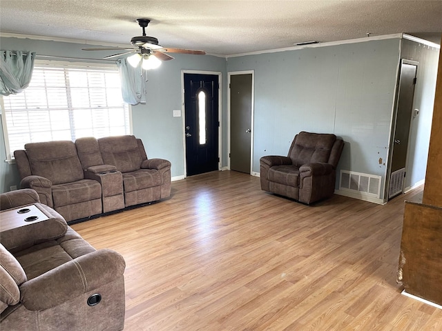 living room with ceiling fan, light hardwood / wood-style floors, crown molding, and a textured ceiling