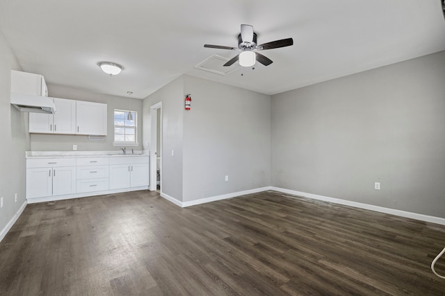 kitchen with dark hardwood / wood-style flooring, ceiling fan, sink, and white cabinetry