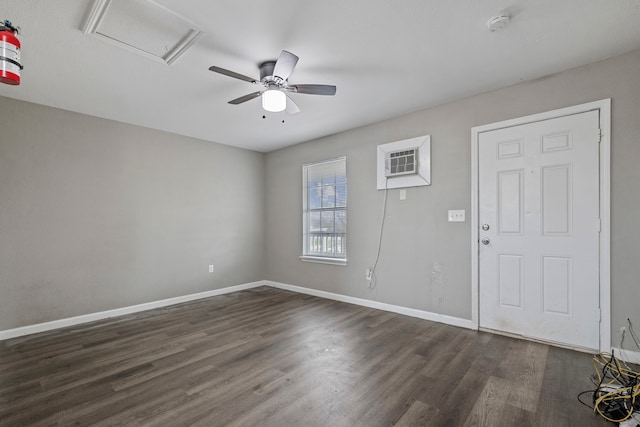 spare room with ceiling fan, dark wood-type flooring, and a wall unit AC