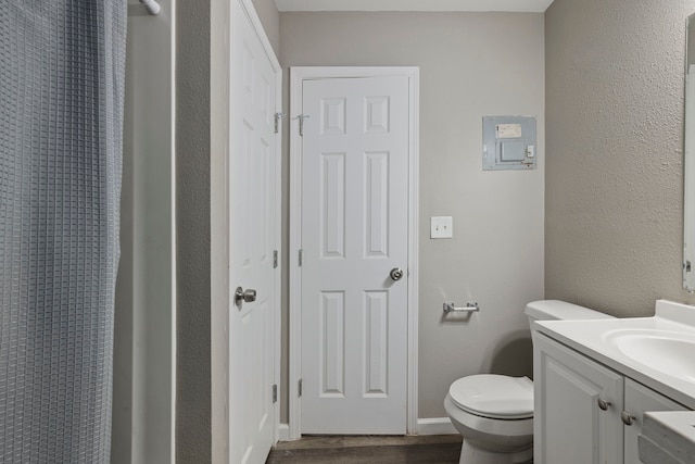 bathroom with toilet, wood-type flooring, and vanity