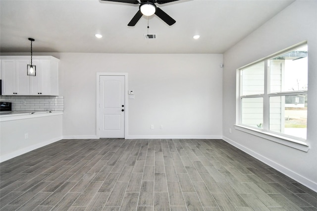 unfurnished living room featuring ceiling fan and wood-type flooring