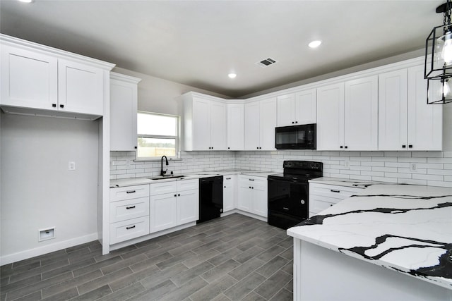 kitchen featuring pendant lighting, black appliances, sink, light stone counters, and white cabinetry