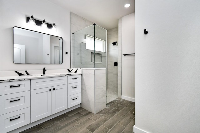 bathroom with a tile shower and vanity