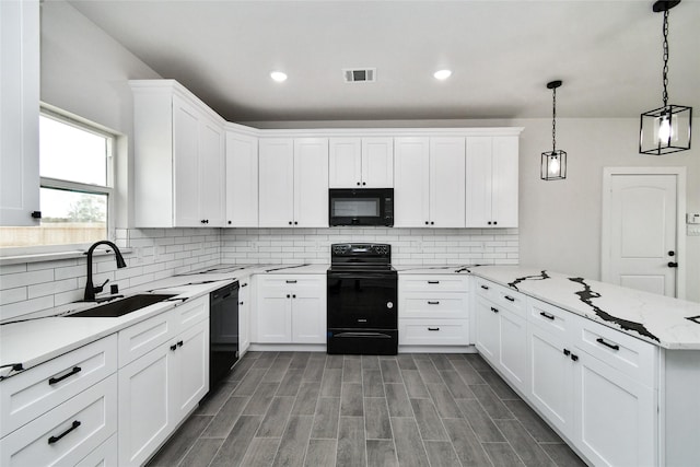 kitchen featuring hanging light fixtures, white cabinets, and black appliances