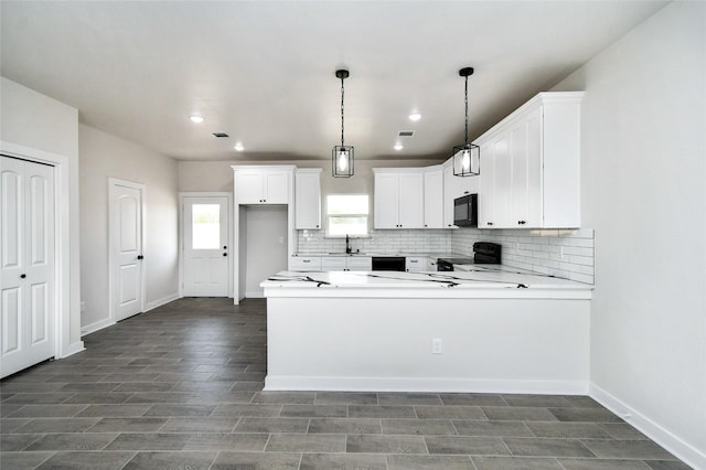 kitchen featuring white cabinetry, sink, kitchen peninsula, decorative light fixtures, and black appliances