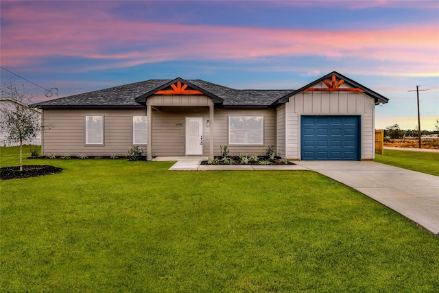 view of front of house with a garage and a yard