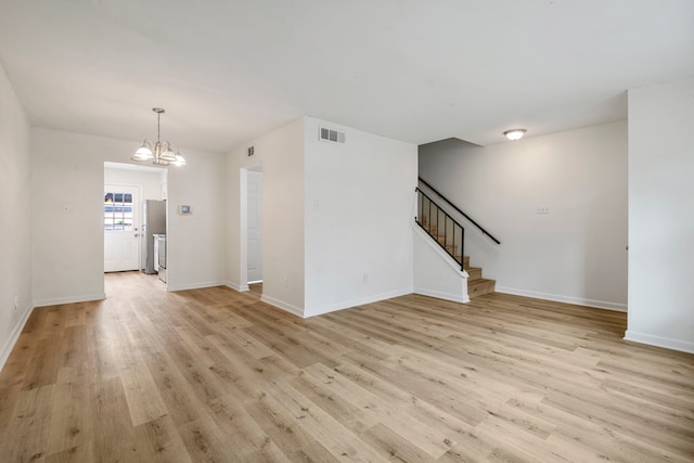 unfurnished living room with light hardwood / wood-style flooring and a notable chandelier