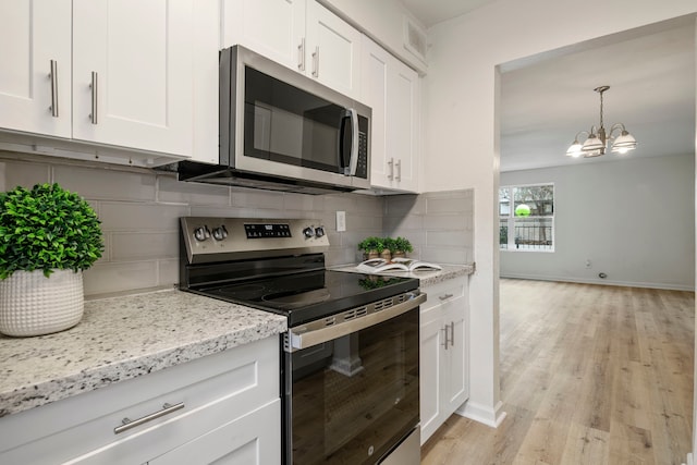 kitchen featuring decorative backsplash, white cabinetry, stainless steel appliances, and light hardwood / wood-style flooring