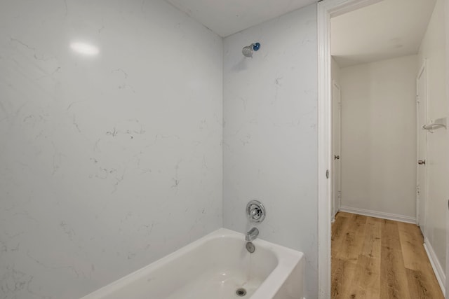 bathroom featuring hardwood / wood-style floors and tiled shower / bath