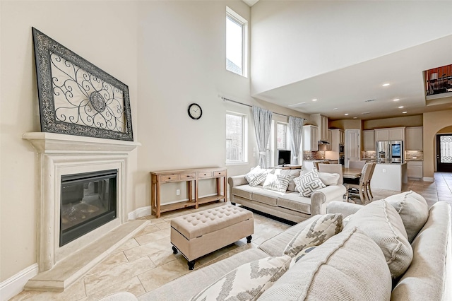 tiled living room with plenty of natural light and a towering ceiling