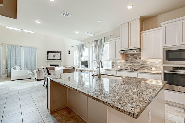 kitchen featuring sink, light stone countertops, white cabinetry, and stainless steel appliances