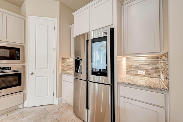 kitchen with decorative backsplash, light stone countertops, white cabinetry, and stainless steel appliances