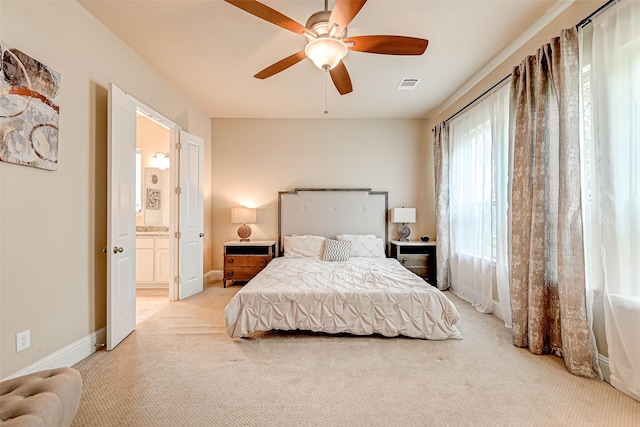 carpeted bedroom with ceiling fan and ensuite bathroom