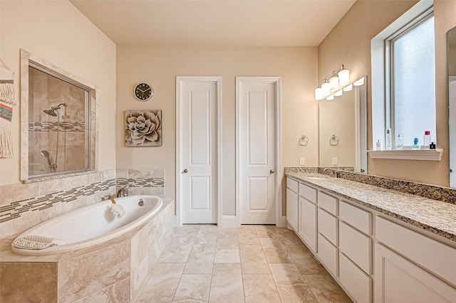 bathroom with vanity and independent shower and bath