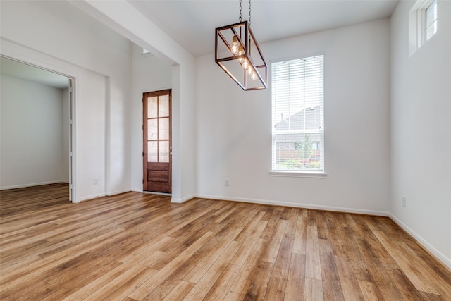 unfurnished dining area featuring light wood-type flooring