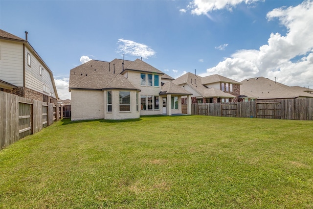 rear view of house featuring a yard