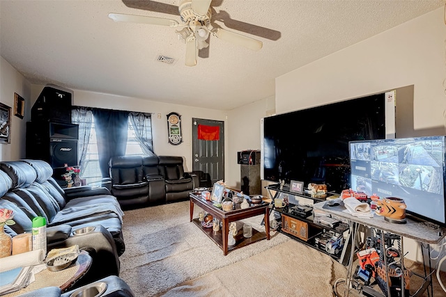 carpeted living room featuring ceiling fan and a textured ceiling