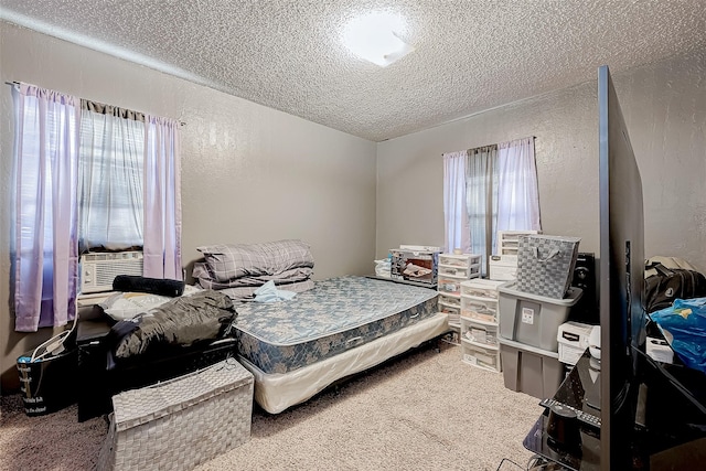 bedroom featuring carpet, cooling unit, a textured ceiling, and multiple windows