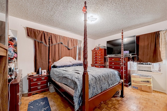 bedroom with parquet floors and a textured ceiling