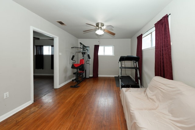 exercise area featuring ceiling fan and dark hardwood / wood-style floors