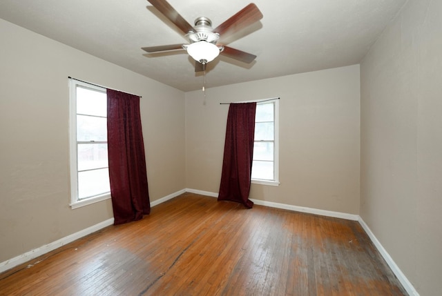 spare room featuring hardwood / wood-style floors, a wealth of natural light, and ceiling fan