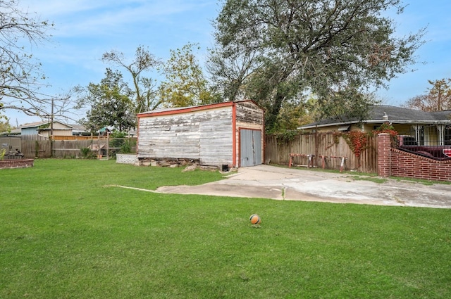 view of yard with a garage, an outdoor structure, and a patio