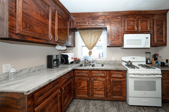 kitchen with light stone countertops, dark brown cabinets, white appliances, sink, and dark hardwood / wood-style floors