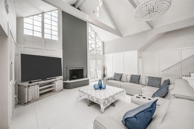 living room featuring beamed ceiling, high vaulted ceiling, a healthy amount of sunlight, and a notable chandelier