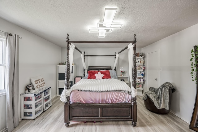 bedroom with a textured ceiling and light hardwood / wood-style flooring