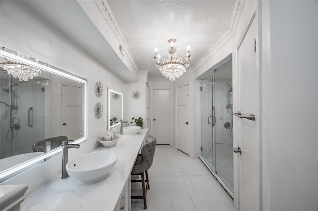 bathroom with double vanity, an inviting chandelier, a sink, and a stall shower