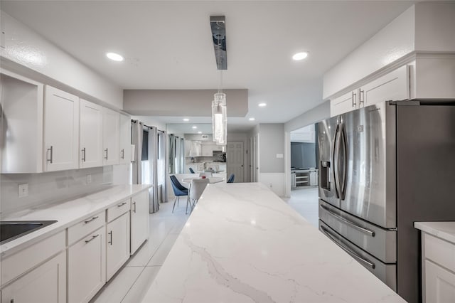 kitchen featuring white cabinets, light stone countertops, stainless steel refrigerator with ice dispenser, and decorative light fixtures