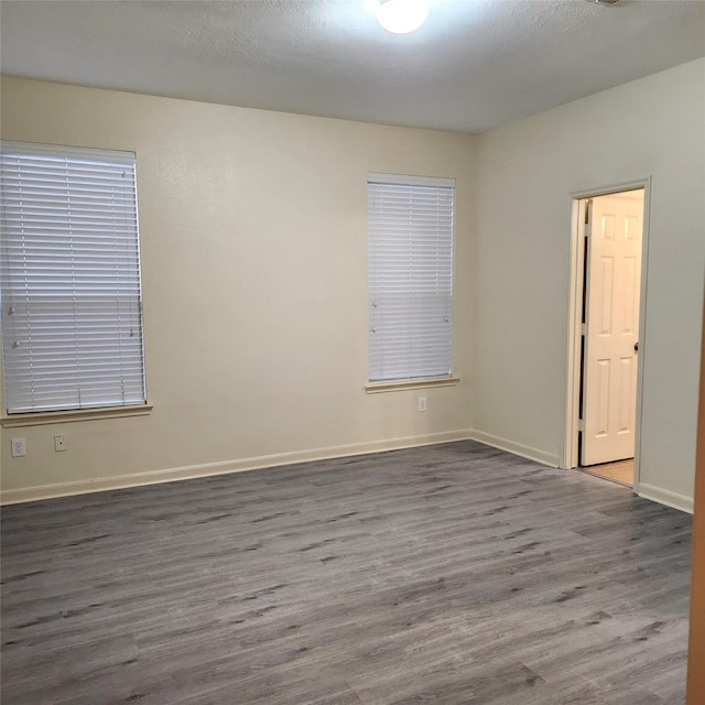 unfurnished room featuring a textured ceiling and dark hardwood / wood-style flooring