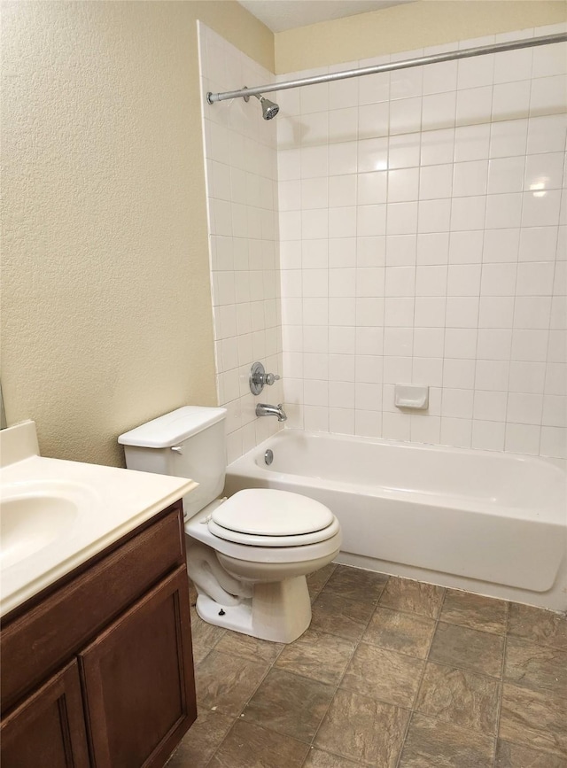 full bathroom with vanity, toilet, and tiled shower / bath combo