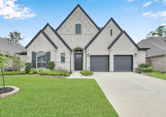 french country style house with a front lawn and a garage