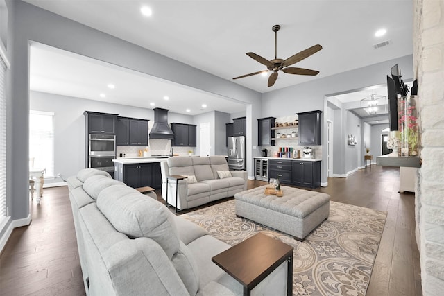 living room with ceiling fan, dark hardwood / wood-style flooring, and indoor bar