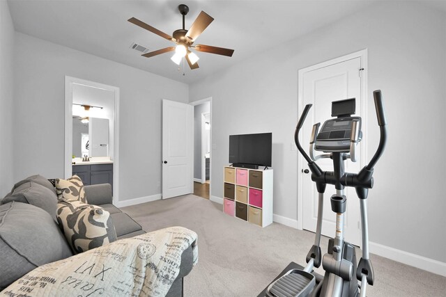 exercise area featuring ceiling fan, sink, and light carpet