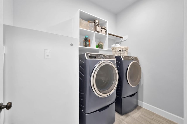 laundry area featuring independent washer and dryer and light hardwood / wood-style flooring